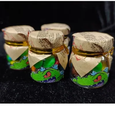 Dulces Reptar Rugrats en frascos con diseño animado del dinosaurio verde